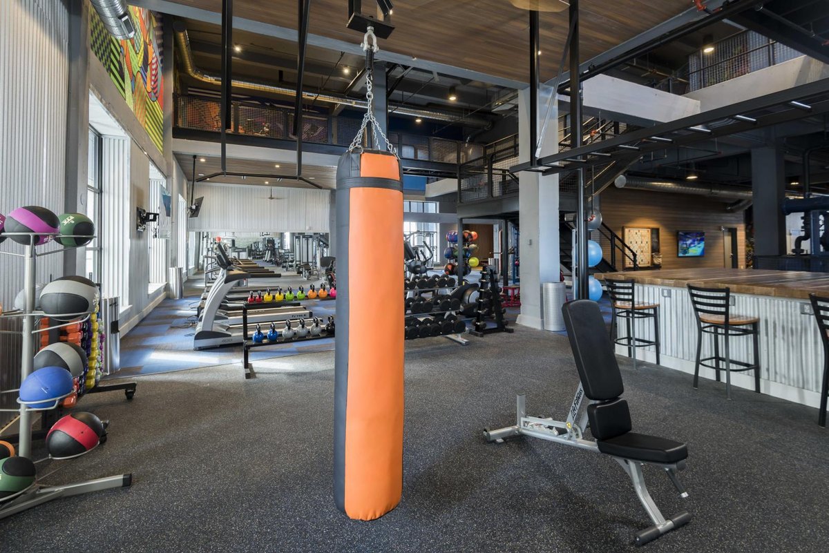 Gimnasio de amenidades con piso de caucho Ecore, zona de cardio, banco y costal de box